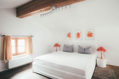 a white bedroom with a white bed and a window at Luna Mia 1 Chalet in Schwangau