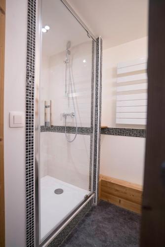 une salle de bain avec une douche avec une porte vitrée dans l'établissement Village De Vacances Les Flocons Verts, aux Carroz d'Arâches