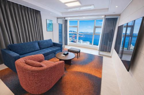 a living room with a blue couch and a table at Matie Busan Harbor City in Busan