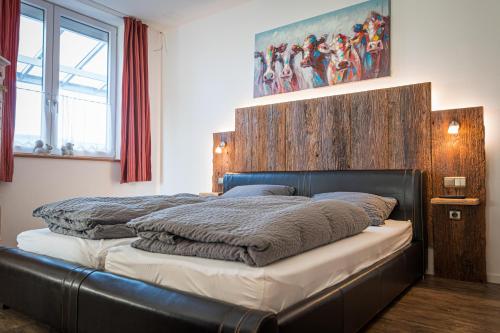 a bedroom with a large bed with a wooden headboard at Hopfenalm in Ilmmünster