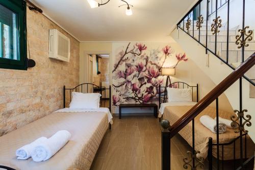 two beds in a room with a painting on the wall at Dukes Poolside Houses in Paralio Astros