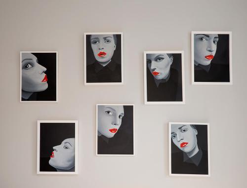 a group of framed portraits of a woman with red lipstick at Artagonist Art Hotel in Vilnius
