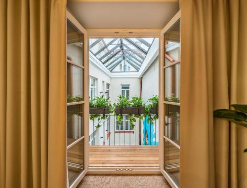 an internal view of a room with windows and plants at Artagonist Art Hotel in Vilnius