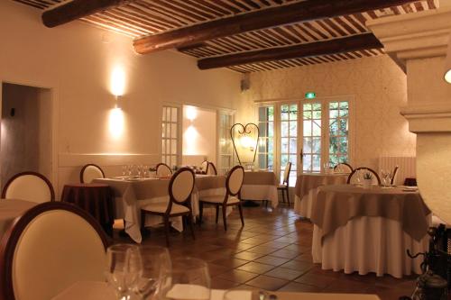 - un restaurant avec des tables et des chaises dans une salle dans l'établissement Hotel Mas De Cure Bourse, à LʼIsle-sur-la-Sorgue