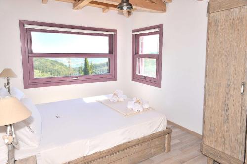 a bedroom with a bed with two stuffed animals on it at Mounty Island Villas in Lazaráta