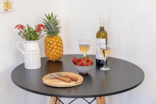 a black table with a pineapple and wine glasses at Avra Charming House in Khelmáta