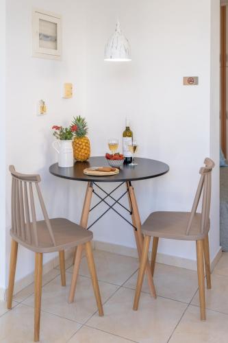 a dining table with two chairs and a table with food on it at Avra Charming House in Khelmáta
