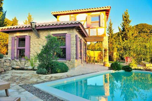 a house with a swimming pool in front of a house at Mounty Island Villas in Lazaráta