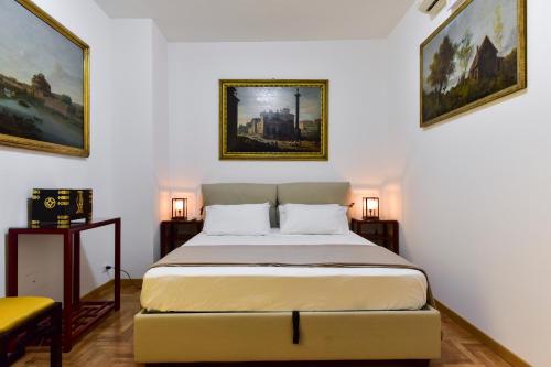 um quarto com uma cama e duas pinturas na parede em Elite Rome Apartments em Roma