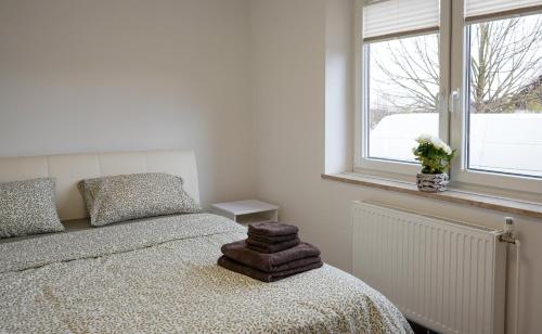 a white bedroom with a bed and a window at Bloom Residence Gomzi in Naklo
