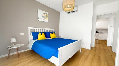 a bedroom with a bed with blue and yellow pillows at Platinum House in Montesilvano