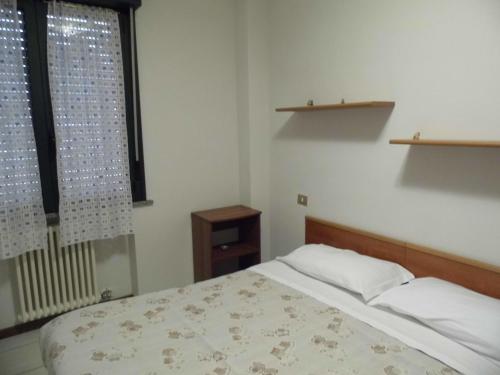 Habitación pequeña con cama y ventana en Bilocale Mentana 21, en Parma