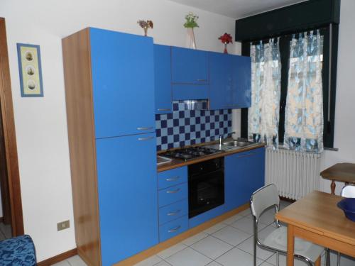 cocina con armarios azules y nevera azul en Bilocale Mentana 21, en Parma