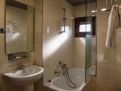 een badkamer met een bad, een wastafel en een douche bij Hospederia de Loarre in Loarre