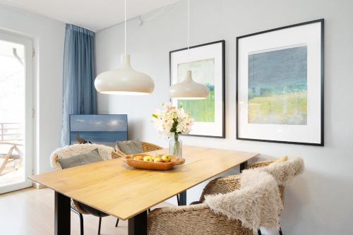 a dining room with a wooden table and chairs at Waldstraße 2 Windrose Kellenhusen in Kellenhusen