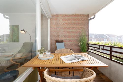 a small balcony with a wooden table and chairs at Waldstraße 2 Windrose Kellenhusen in Kellenhusen