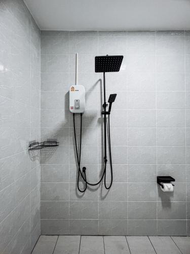 a shower in a bathroom with a black hose at L.C. Apartments in Lamai
