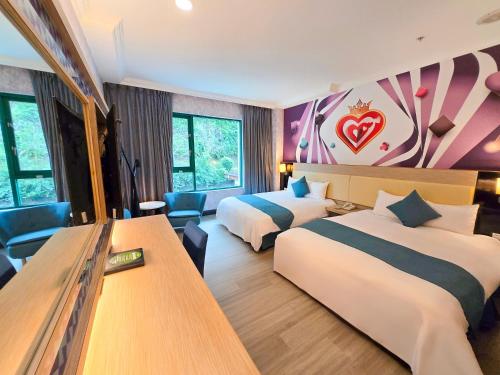 a hotel room with two beds and a desk at Uni-Resort Mawutu in Guanxi
