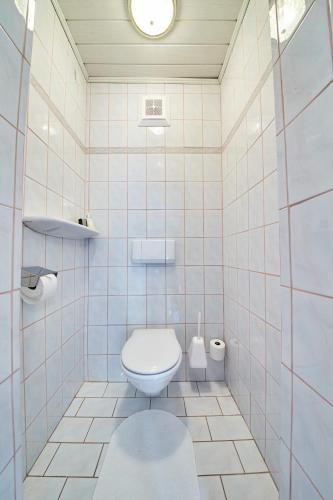 a white tiled bathroom with a toilet in it at Holiday Home Viehhofen in Viehhofen