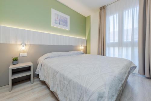 a bedroom with a white bed and a window at Hotel Palladio in Malcontenta