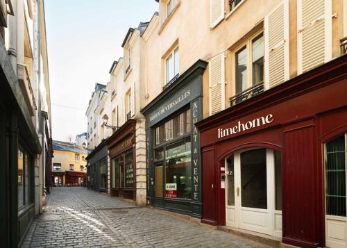 an empty street in a city with buildings at Limehome Versailles Rue du Bailliage in Versailles
