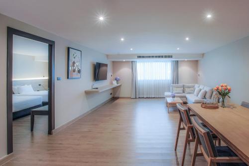 a living room with a couch and a dining room at Alpine Golf Resort Chiang Mai in Ban Huai Sai Nua