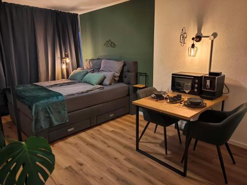a bedroom with a bed and a table with a microwave at MeLou Fewo Harzruhe Wellness in Bad Lauterberg