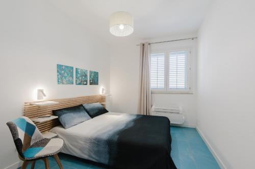 a bedroom with a bed and a chair and a window at Orizzonte Blu apartment - Macari Bay in Macari