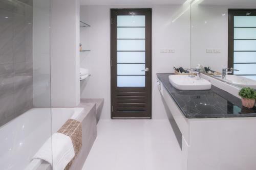 a bathroom with a sink and a toilet and a mirror at Alpine Golf Resort Chiang Mai in Ban Huai Sai Nua