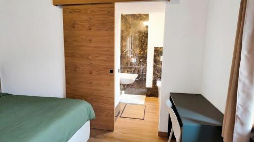 a bedroom with a bed and a bathroom with a sink at Casa Ereva in Bagnoli Irpino