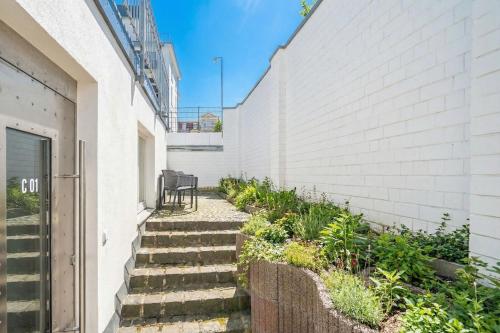 a set of stairs next to a white wall at Villa Seedüwel - App C01 in Ahlbeck