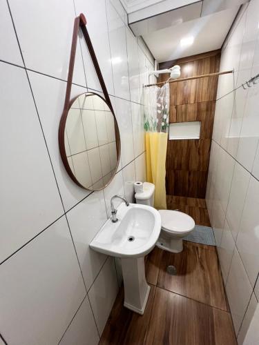 a bathroom with a sink and a mirror and a toilet at 10 MIN AEROPORTO GUARULHOS in Guarulhos