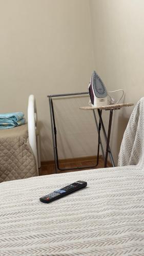 a remote control sitting on a bed next to a table at Апартаменты 3а in Aktau