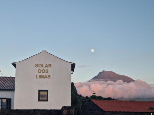 a white building with a sign on the side of it at Solar dos limas in Criação Velha