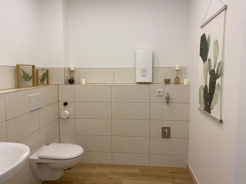 a white bathroom with a toilet and a sink at Deck in Cuxhaven