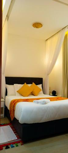 a bedroom with a large bed with yellow pillows at Bonds Hotel in Nairobi