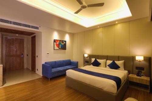 a bedroom with a bed and a blue couch at BB Grand in Sunām
