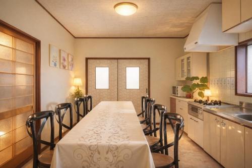 a dining room with a table and chairs in a kitchen at 絶景貸切別荘in山海荘 無料専用BBQスペースと駐車場付 in Shirahama
