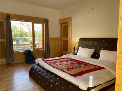 a bedroom with a large bed with a large window at AO Guest House in Nubra