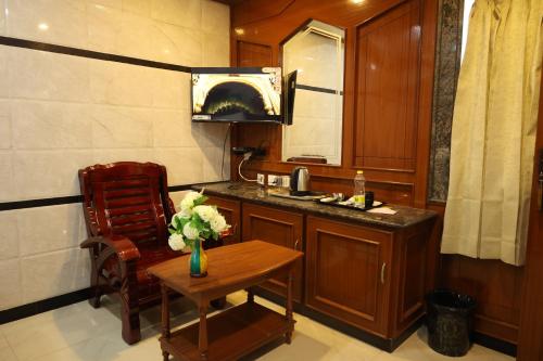 a bathroom with a sink and a table and a chair at SVS Grand in Dindigul
