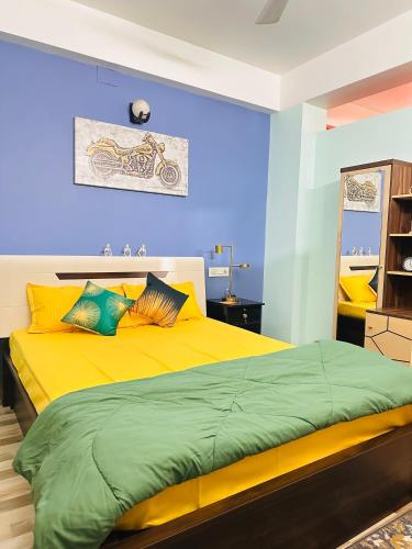 a bedroom with a yellow bed and blue walls at J kutir in Siliguri