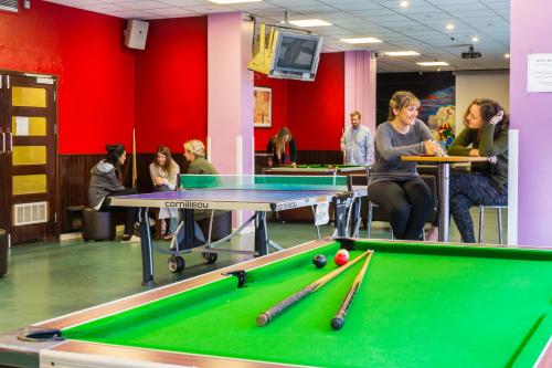 een groep mensen in een kamer met een pooltafel bij International Hall / University of London in Londen