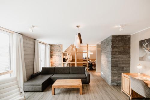 a living room with a black couch and a table at StrandBerg's Stadt Chalet in Braunlage