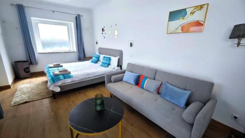 a living room with a couch and a bed at Cascais Garden House in Cascais