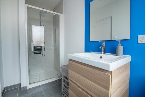 a bathroom with a white sink and a shower at L'Echappée Choletaise, simple et familiale! in Cholet