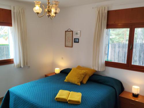 a bedroom with a bed with two yellow towels on it at La Campanera in Las Navas del Marqués