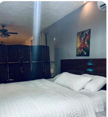 a bedroom with a large white bed with a ceiling at Bomi Bar in King Faro