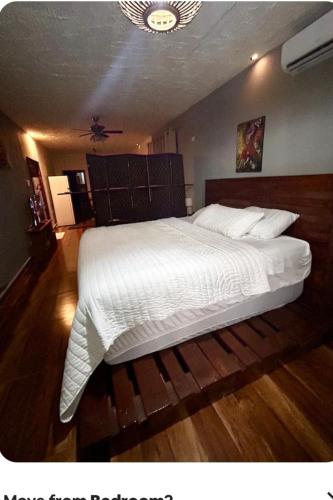 a bedroom with a large bed with white sheets at Bomi Bar in King Faro