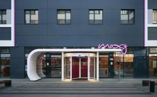a building with a sign on the front of it at Moxy Munich Messe in Aschheim