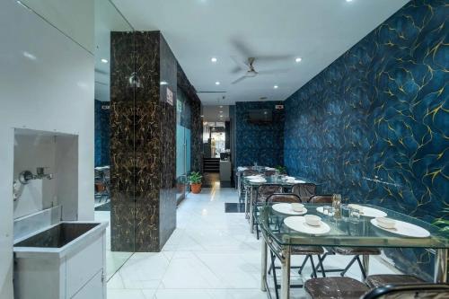 a restaurant with tables and chairs and a blue wall at Glitz Rexton Inn - Near IIT Powai in Mumbai